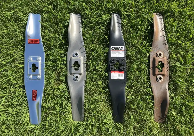 Top rated zero turn mower blade brands including Oregon Gator and OEM blades arranged on lawn for real world comparison