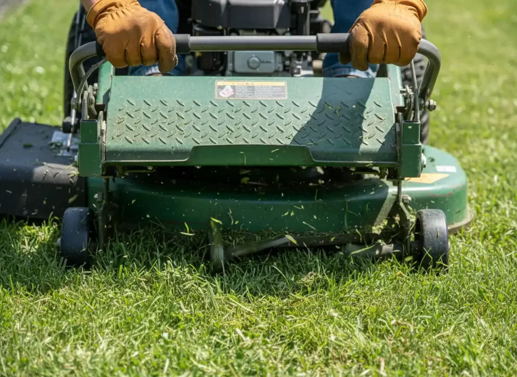 Operator point of view using commercial walk behind mower showing controls and cutting deck